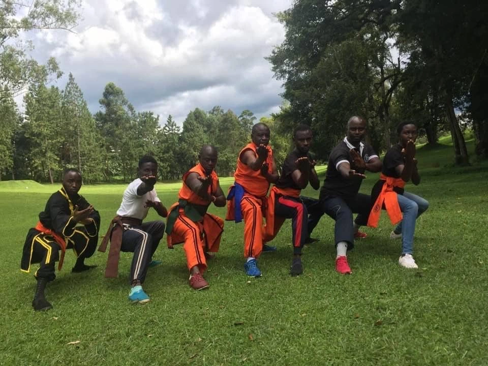 Martial arts group in orange uniforms outdoors